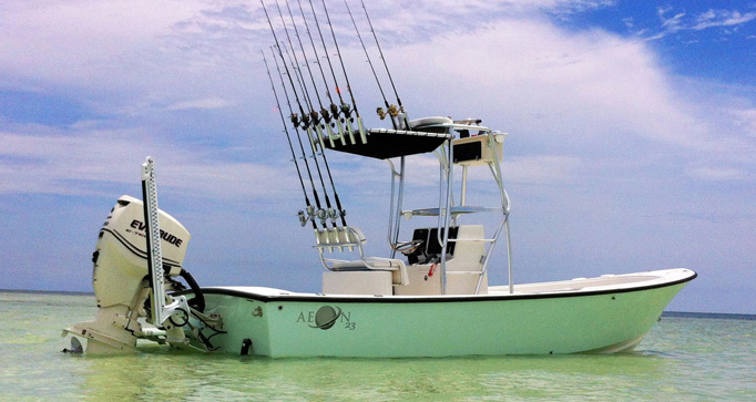 23′ Bay Boat equipped for inshore fishing, featuring multiple fishing rods, anchored in clear water, ideal for 1-4 anglers seeking a spacious charter experience in the Florida Keys.