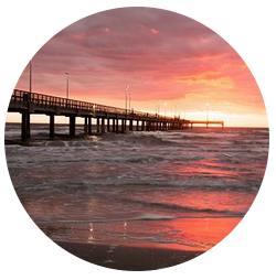 Fishing pier at sunset with vibrant sky and reflecting waves, illustrating the scenic beauty of fishing trips in the Florida Keys.