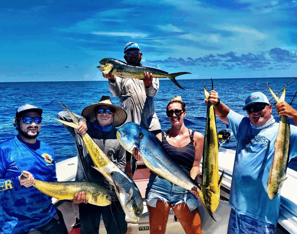 Group of anglers holding large mahi-mahi fish on a fishing charter in the Florida Keys, with a vibrant ocean backdrop, emphasizing offshore fishing experiences.