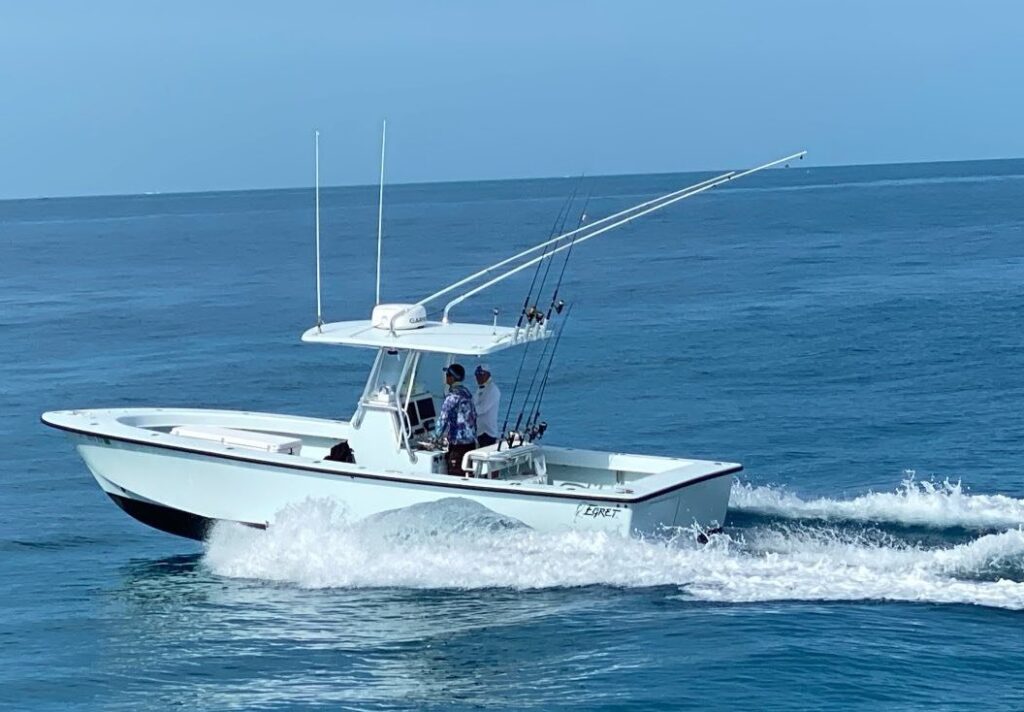 30′ center console fishing boat navigating the waters of the Florida Keys, equipped with fishing rods, designed for offshore fishing and charters, highlighting versatility and performance.