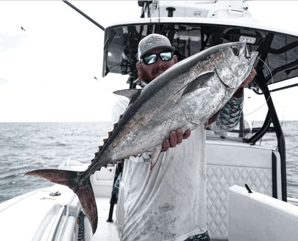 Angler holding a large Blackfin Tuna on a fishing boat in the Florida Keys, showcasing the excitement of offshore fishing adventures.